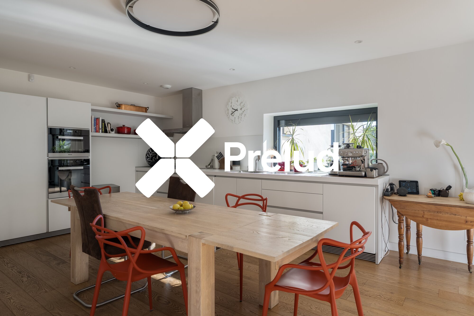 Cuisine ouverte contemporaine avec chaises rouges et grande fenêtre