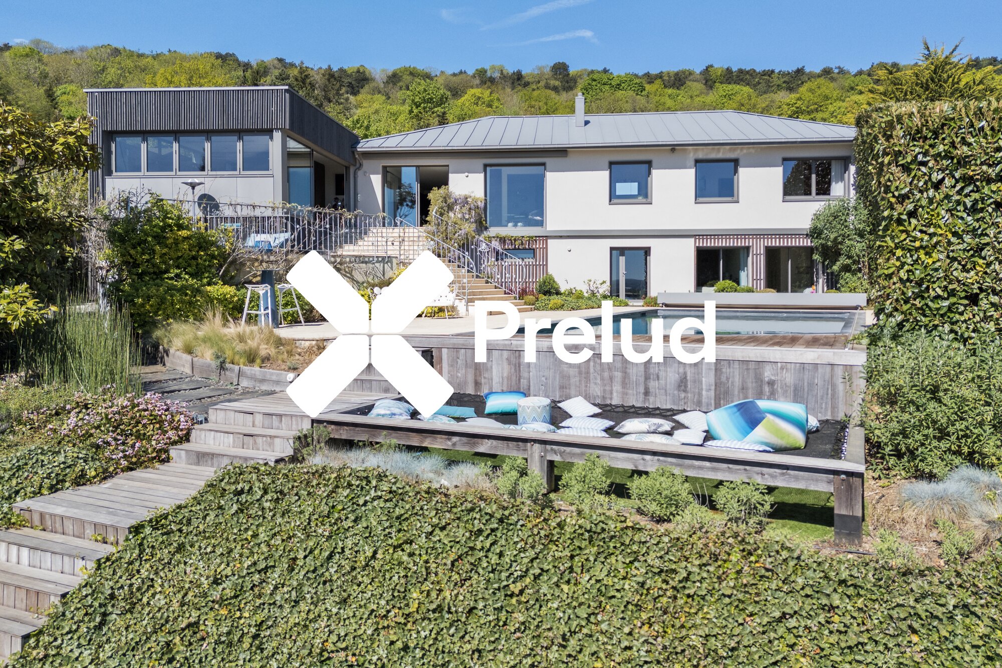 Vue drone aérien de la façade arrière, piscine, terrasse et jardin paysager