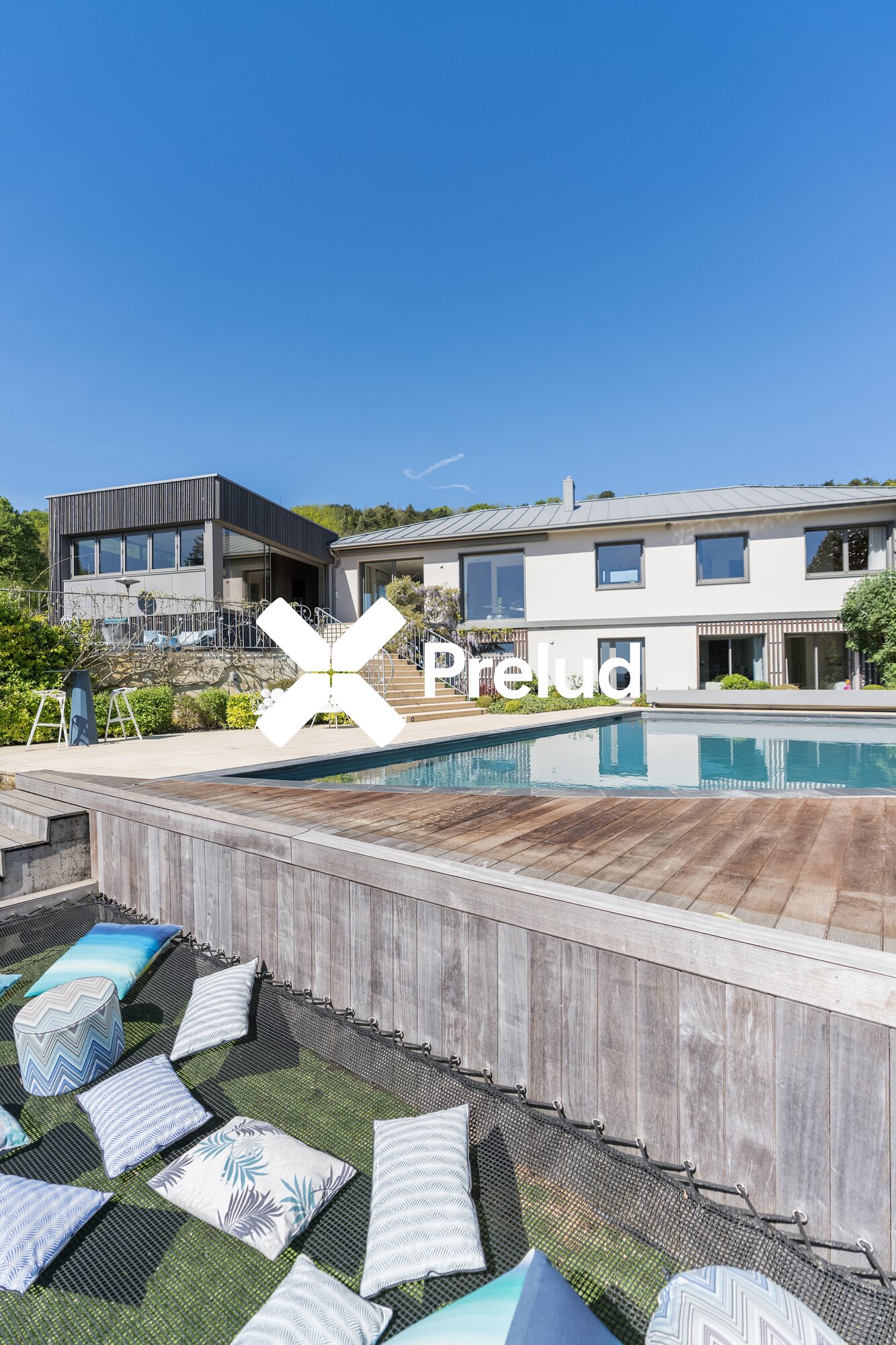 Piscine, coussins de relaxation et façade de la villa